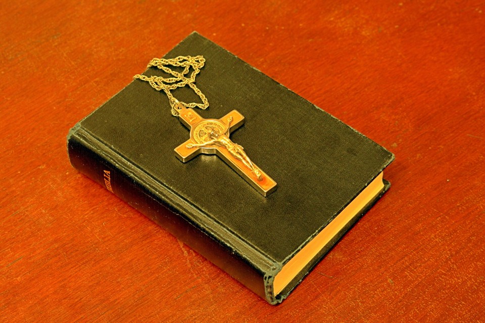 a bible with a cross on top of it