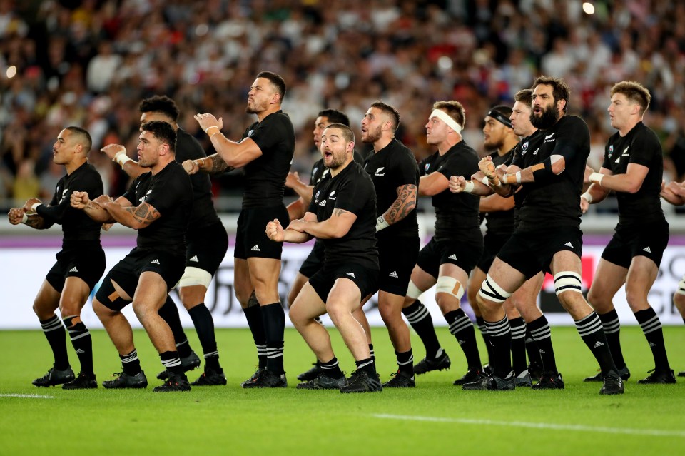 a group of rugby players wearing all black uniforms