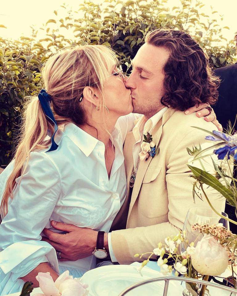 a man and a woman kissing in front of flowers