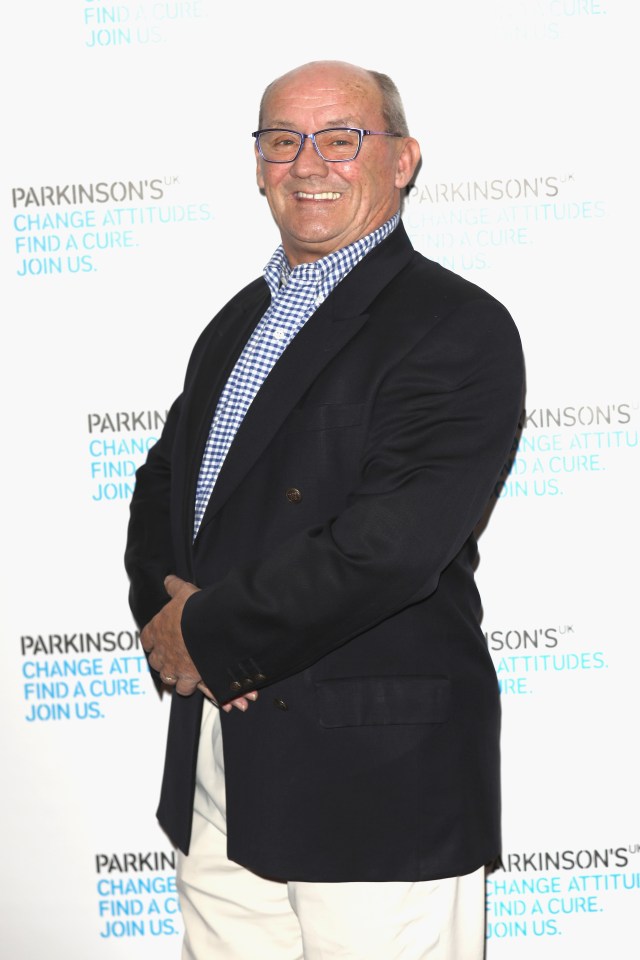 a man stands in front of a sign that says parkinson 's