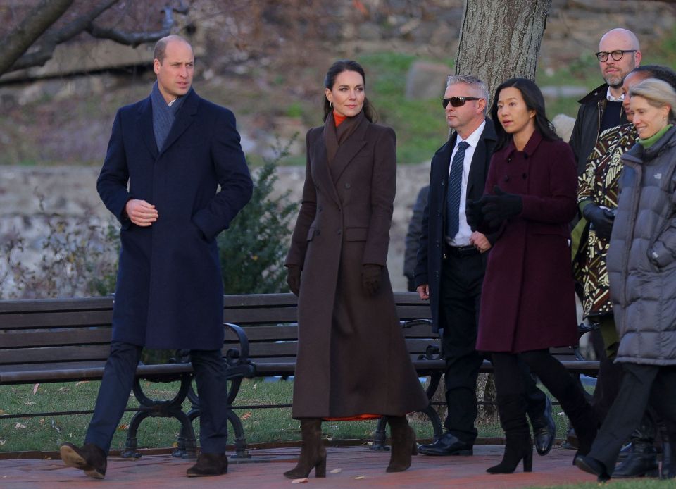 a group of people walking in a park with a man wearing sunglasses