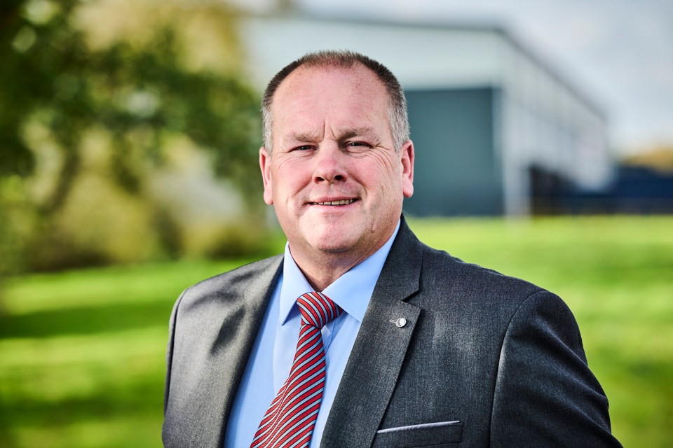 a man in a suit and tie is smiling for the camera