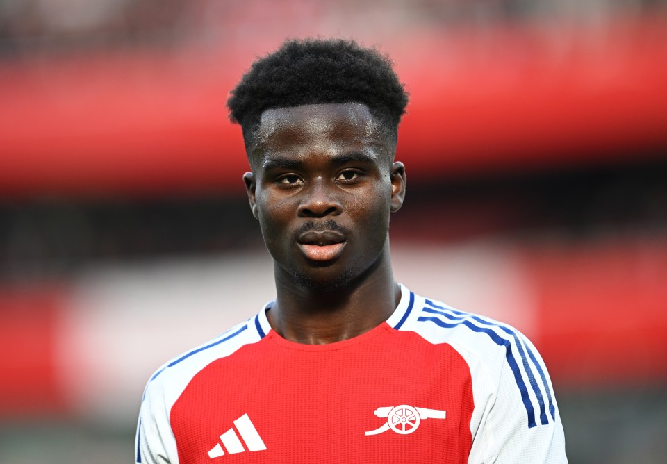 a soccer player wearing a red and white adidas jersey