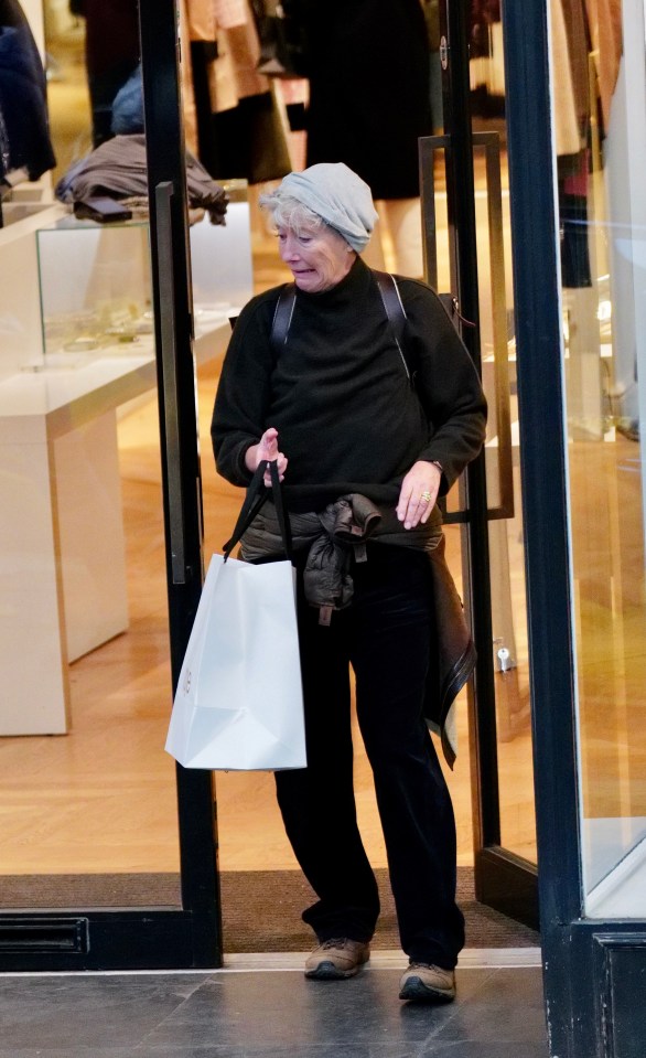 a woman in a black sweater is walking out of a store