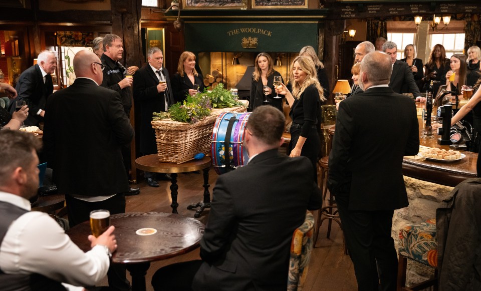 a group of people are gathered in front of a sign that says the woolpack