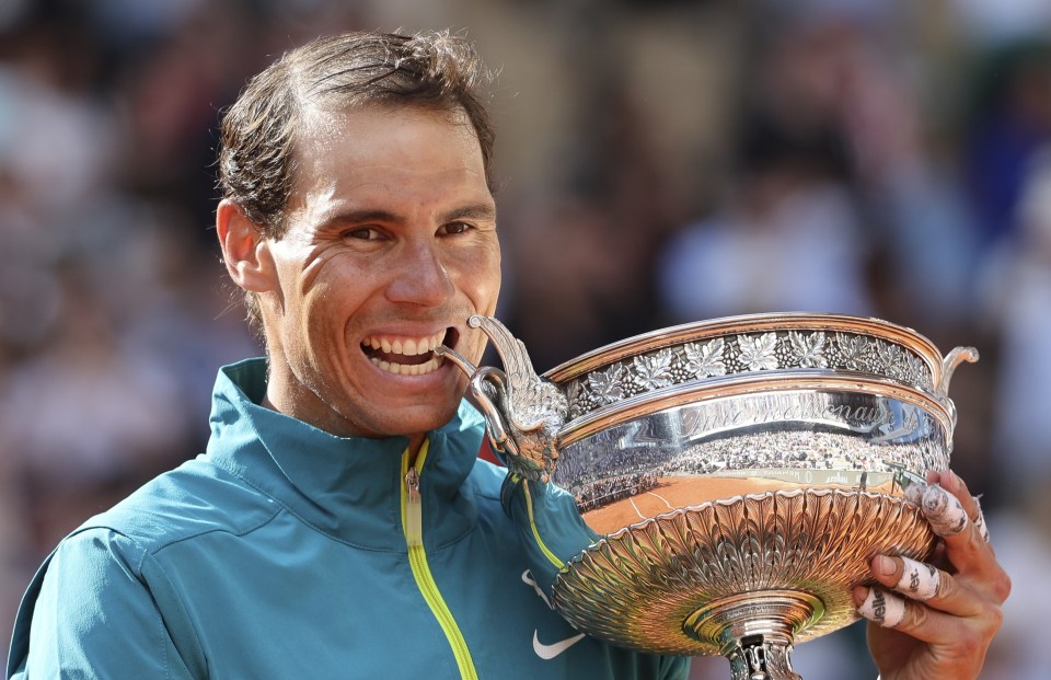 a man is holding a trophy in his hand and smiling