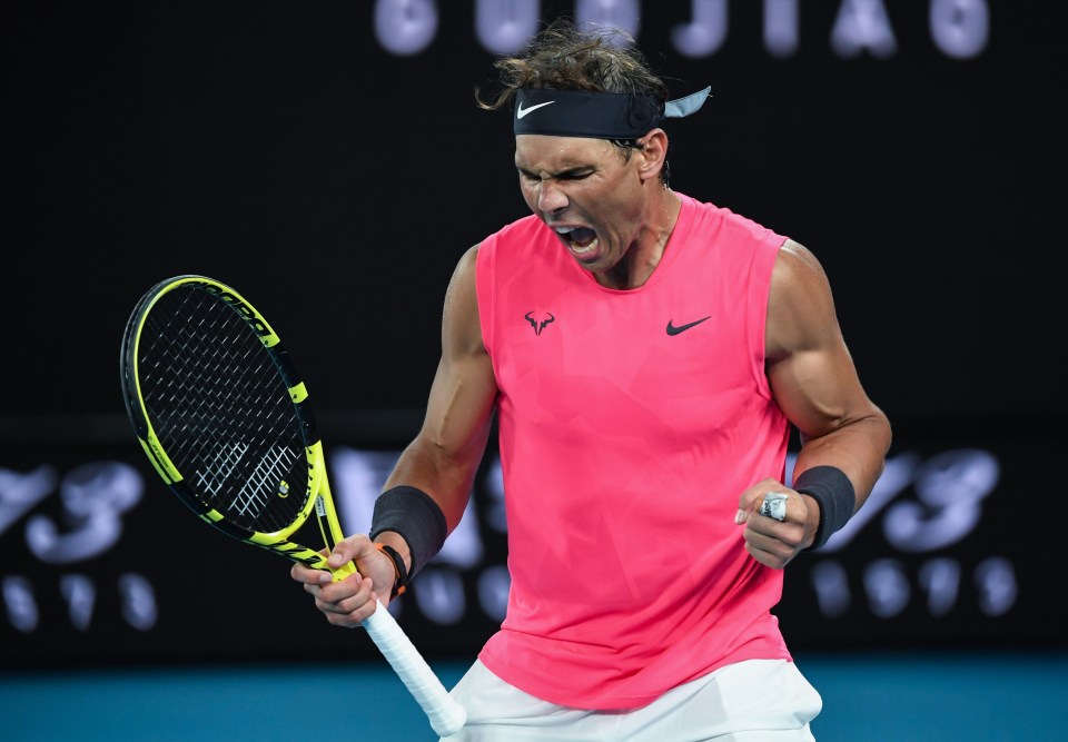 a man in a pink tank top is holding a tennis racquet