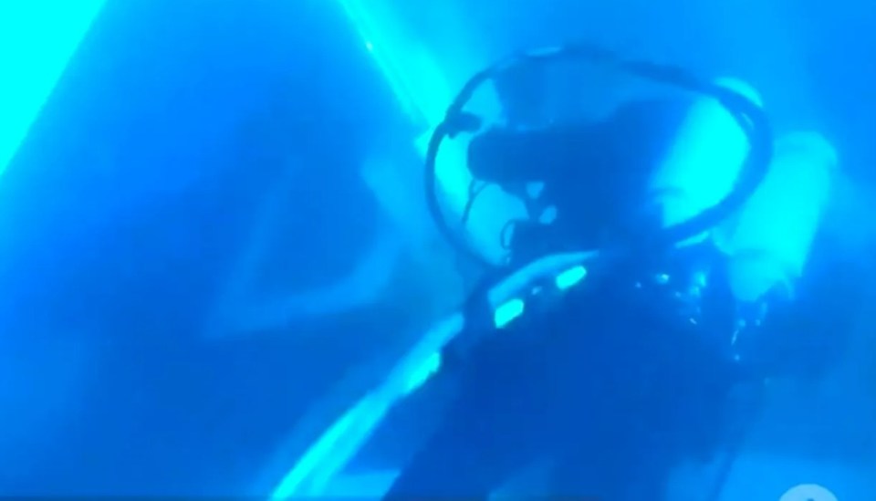 Divers swimming inside the sunken vessel