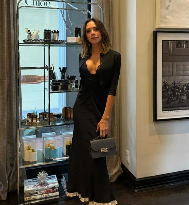 a woman in a black dress is standing in front of a shelf that says chloe