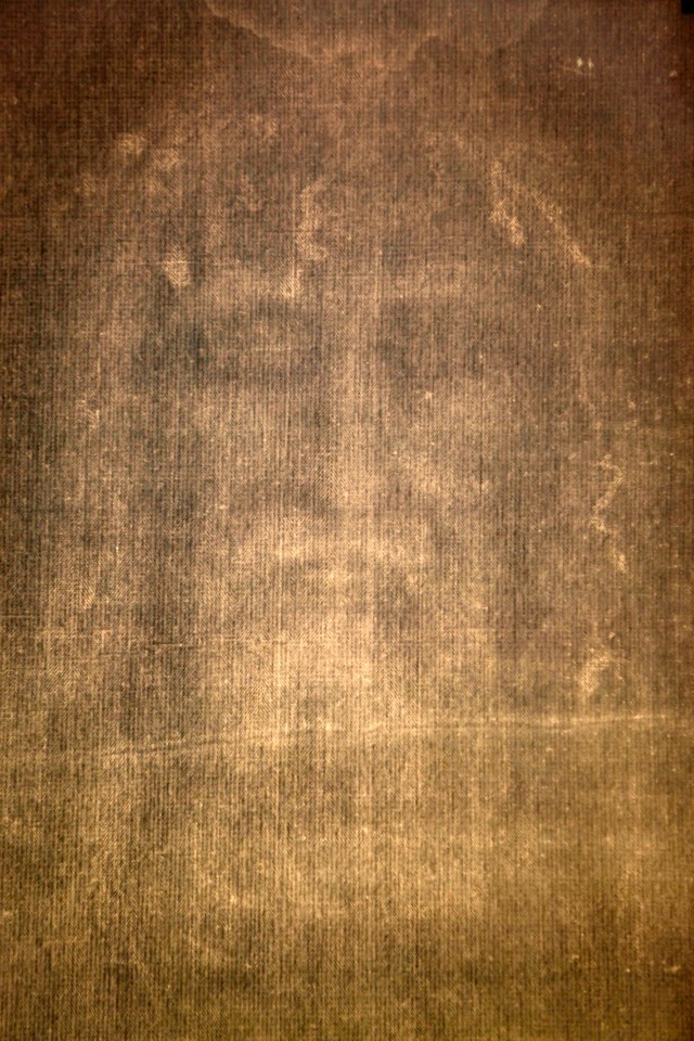 A close-up image of the imprint of the face of a bearded man on the Shroud of Turin