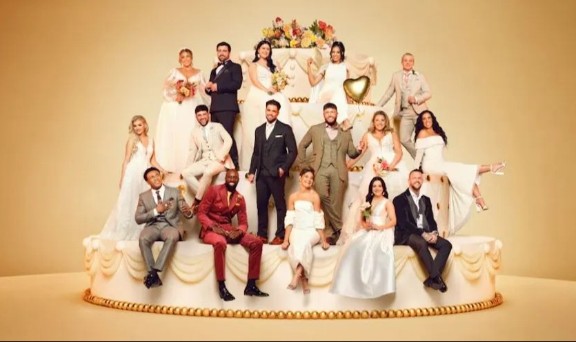 a group of people sitting on top of a wedding cake