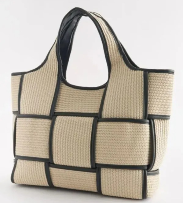 a wicker tote bag with a black handle