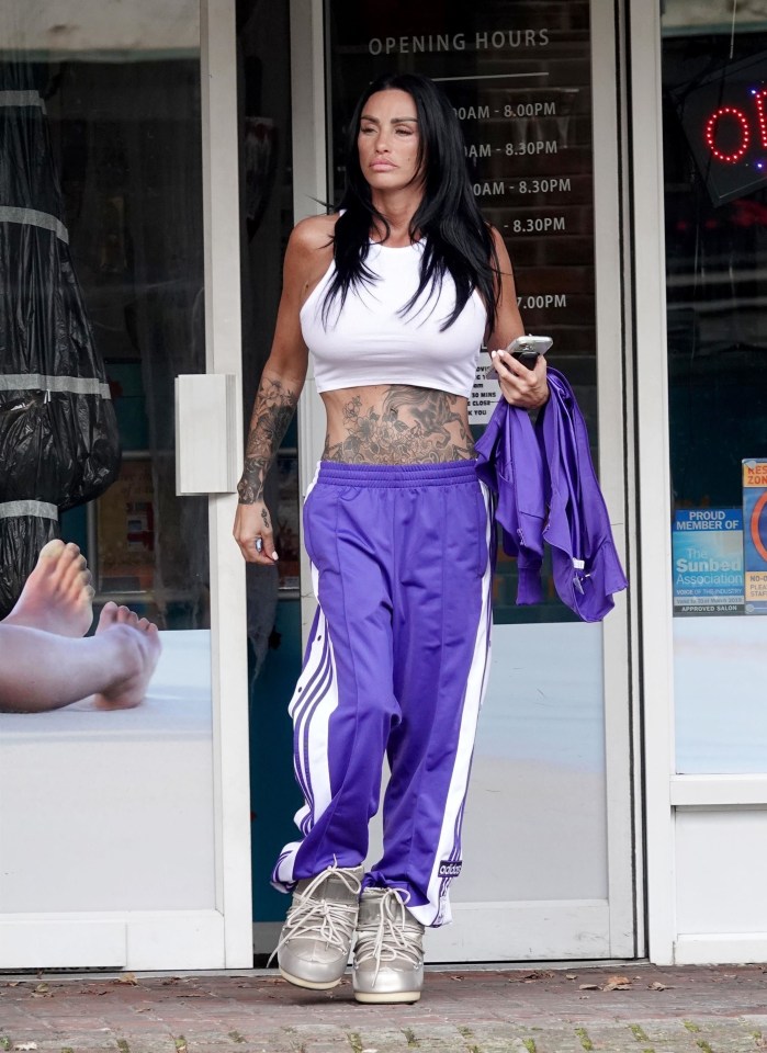 a woman standing in front of a store that says opening hours