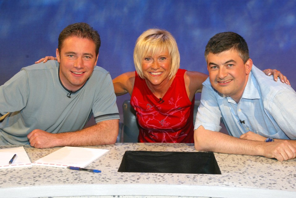 a woman in a red dress sits between two men