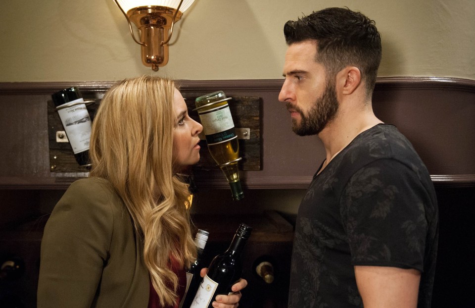 a man and a woman standing next to each other holding wine bottles