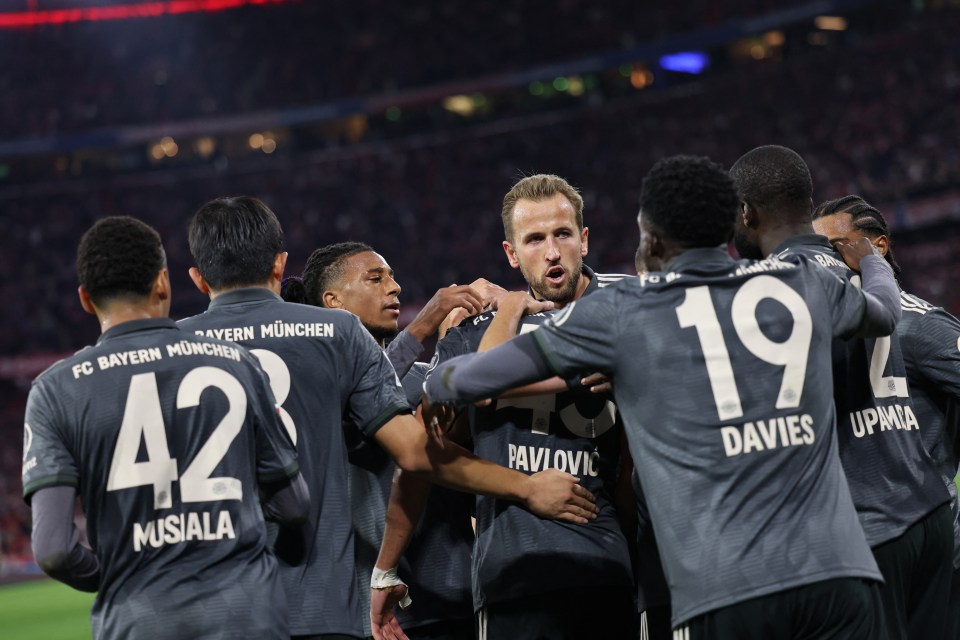 a group of soccer players from fc bayern munchen huddle together