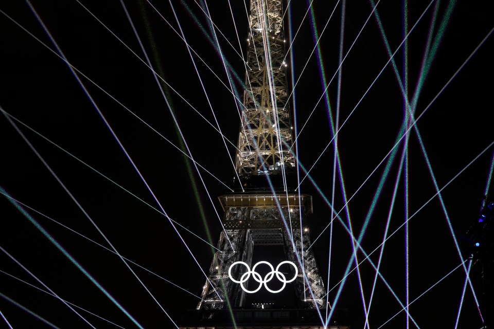 the olympic rings are projected on the eiffel tower