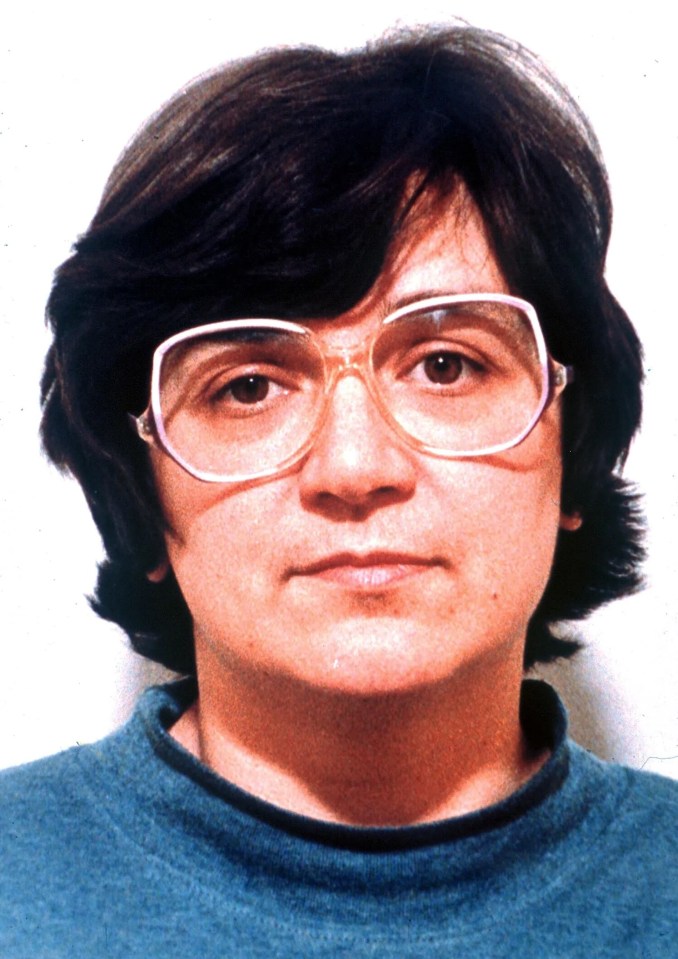 a woman wearing glasses and a blue sweater with the year 1986 on the bottom