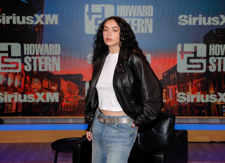 a woman stands in front of a howard stern sign