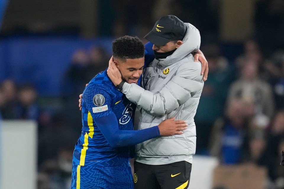 a man in a nike jacket hugging a soccer player