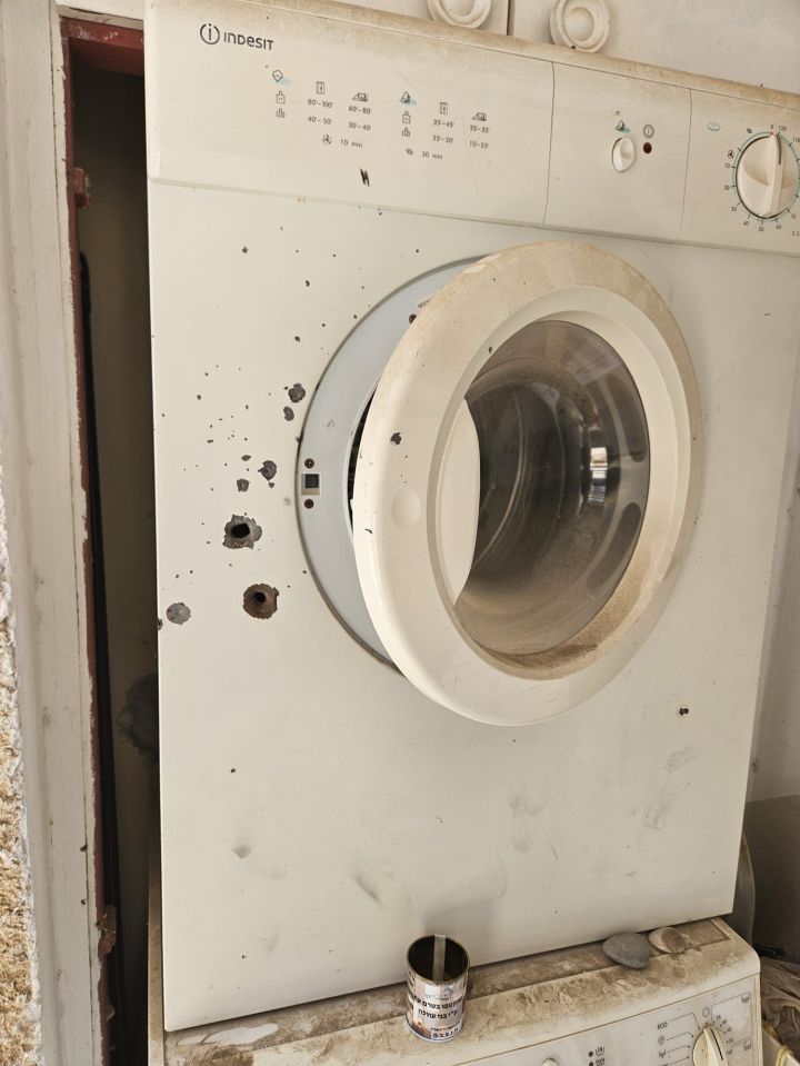 A family's blood-stained washing machine after a grenade went in their home