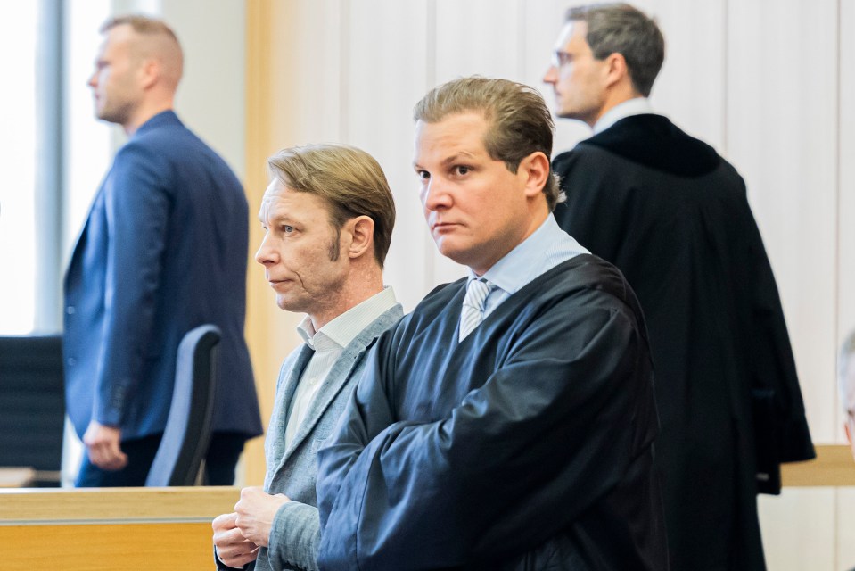 a man in a suit sits next to a judge in a courtroom