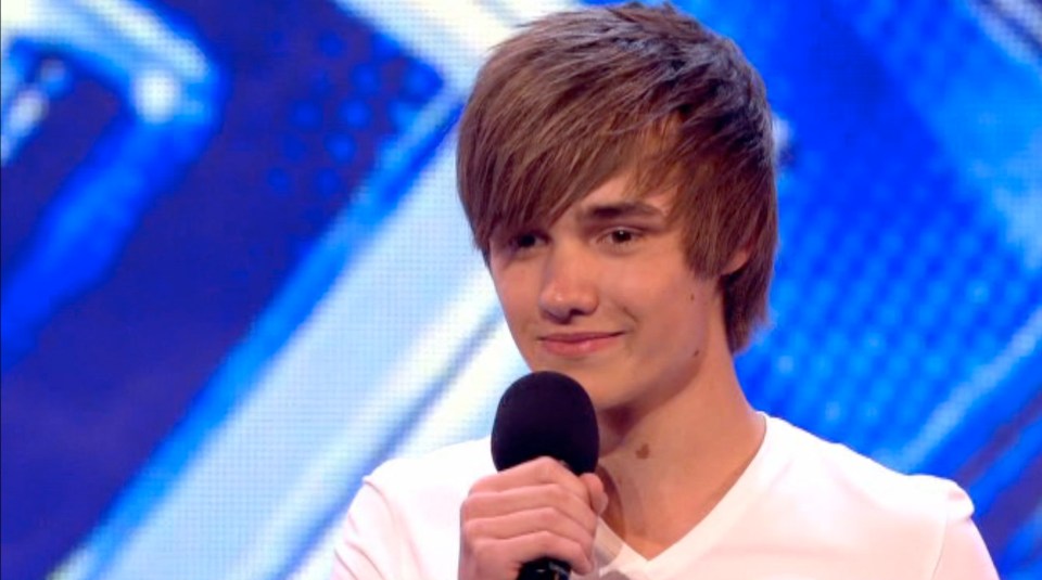 a young man is holding a microphone in front of a blue background