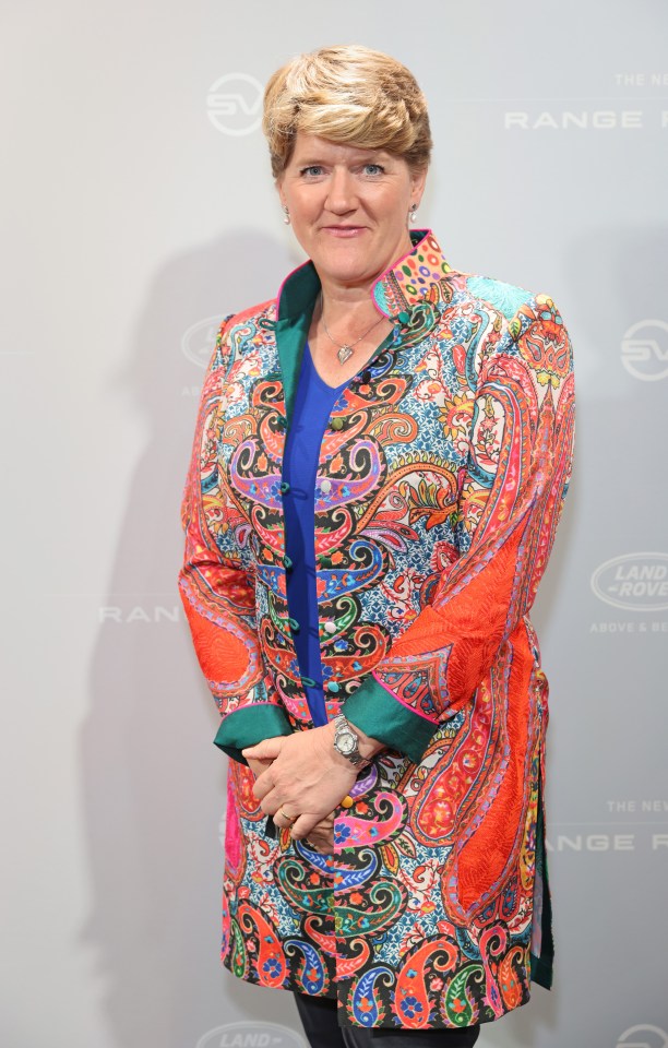 a woman in a colorful jacket stands in front of a wall that says range rover