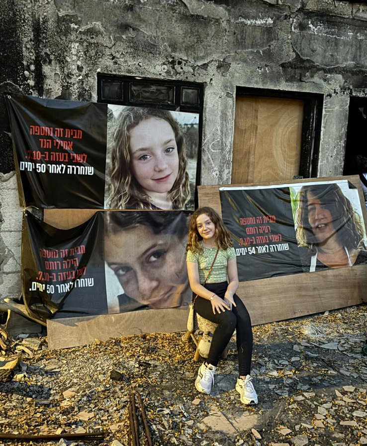 Emily sitting with a poster with her face after Hamas kidnapped her