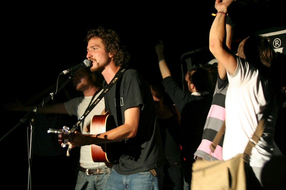 a man singing into a microphone with a strap that says ' nikon ' on it