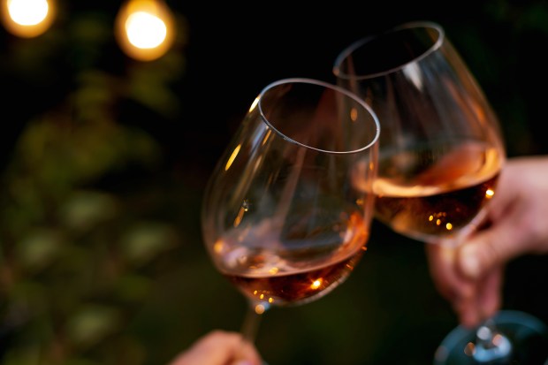 two glasses of wine are being toasted by two people