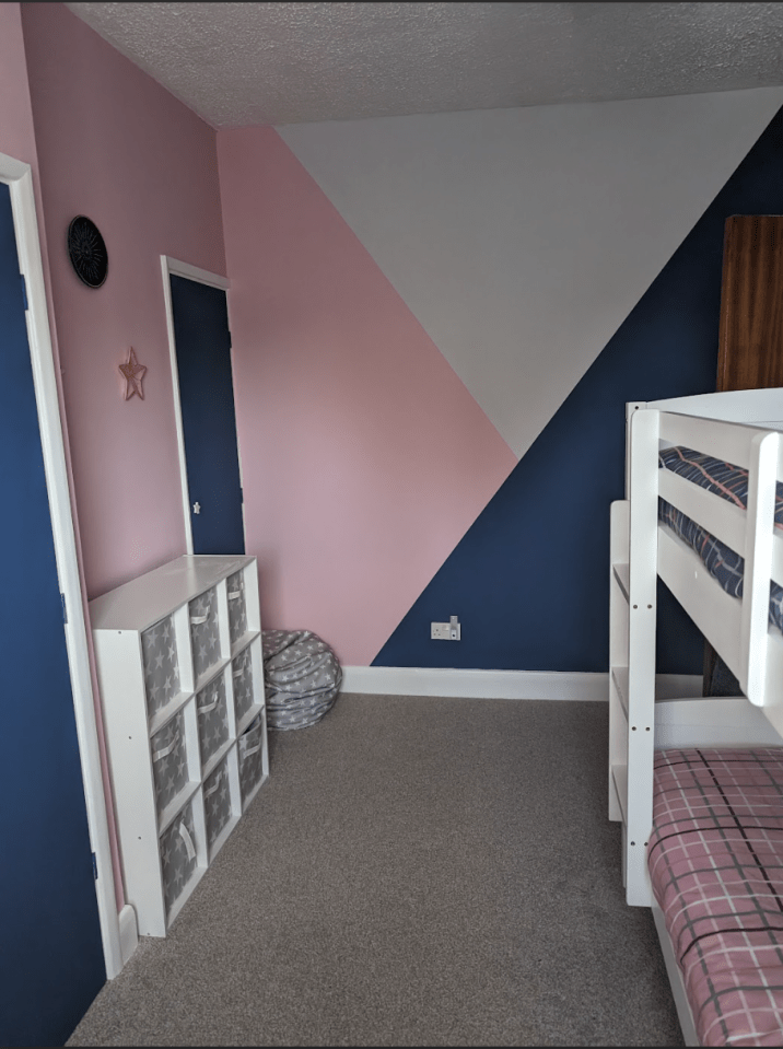 a bedroom with pink and blue walls and a bunk bed