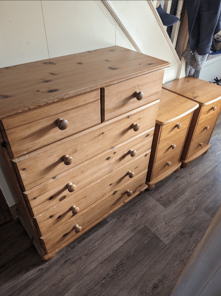 a wooden chest of drawers sits next to two nightstands