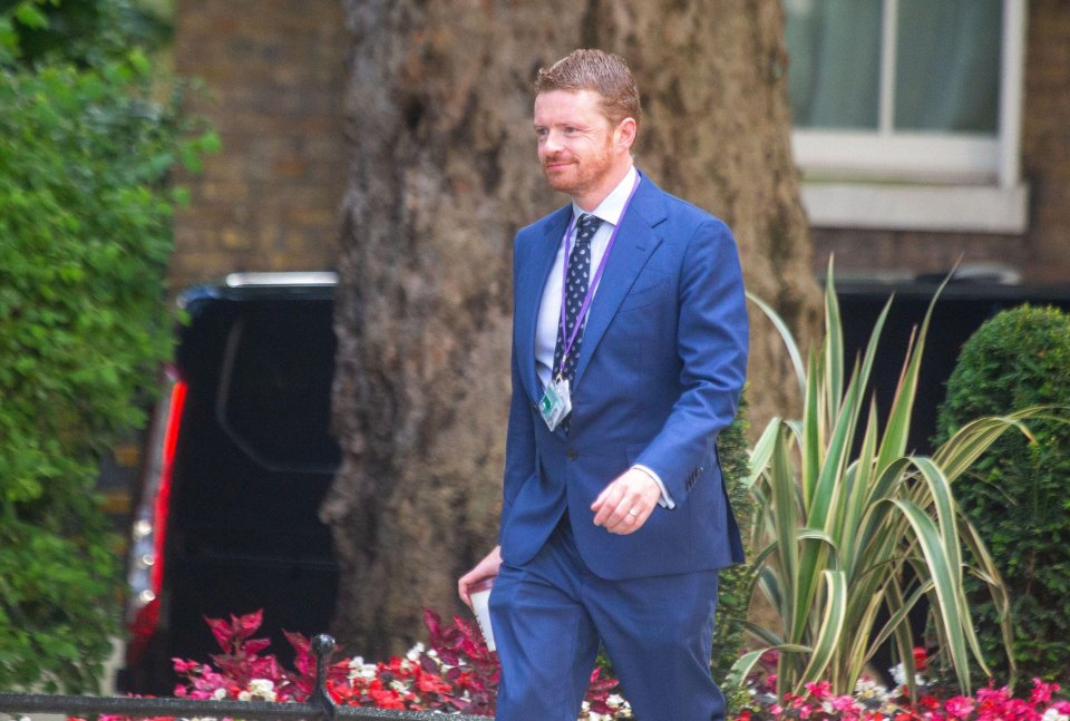 a man in a blue suit has a lanyard around his neck