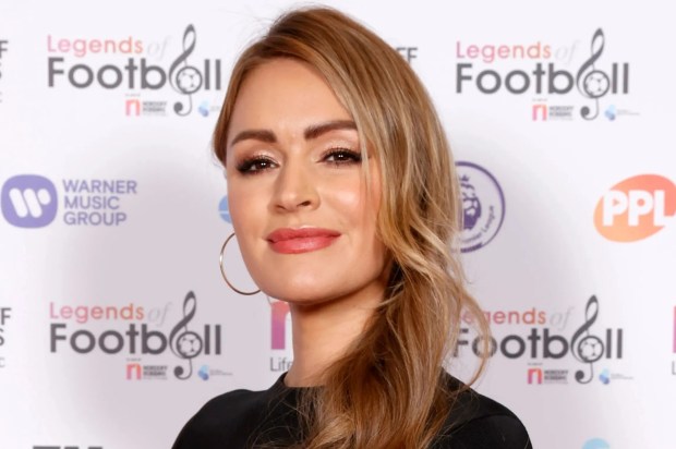 a woman stands in front of a wall that says legends of football