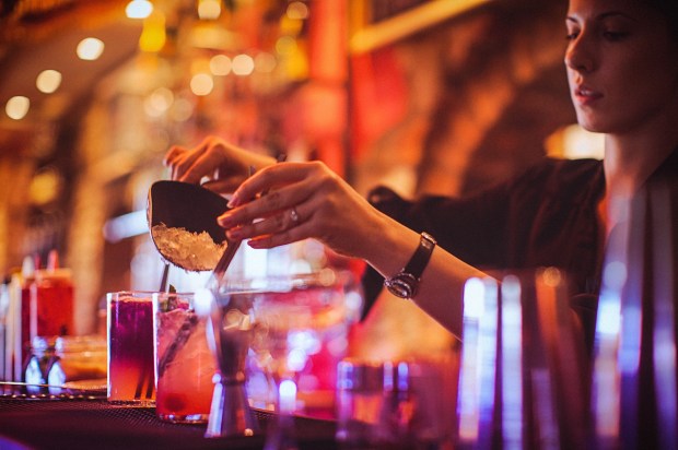 a bartender is pouring a drink into a glass