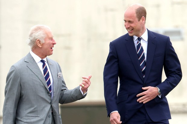 a man in a suit talks to another man in a suit