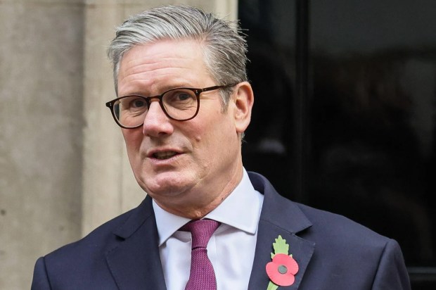 a man in a suit and tie with a poppy pin on his jacket