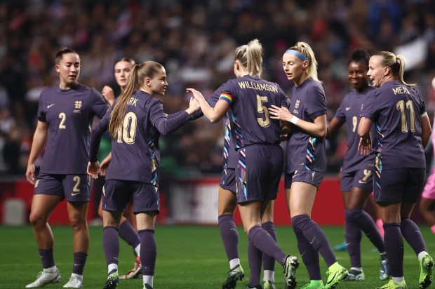 a group of female soccer players with one wearing the number 5