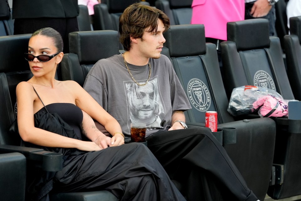 a man and a woman sit in a stadium watching a game