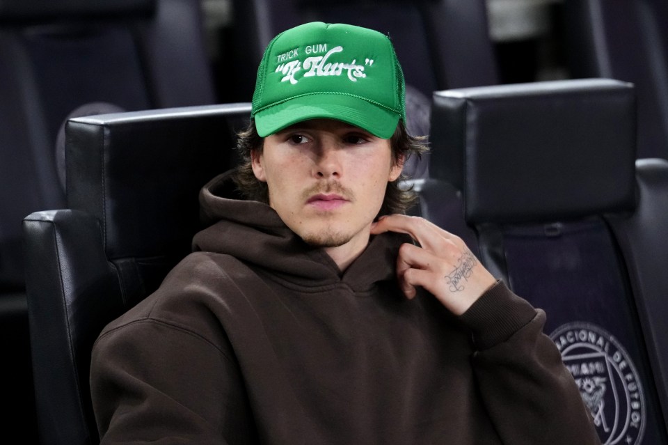 a man wearing a green hat that says knock gum on it