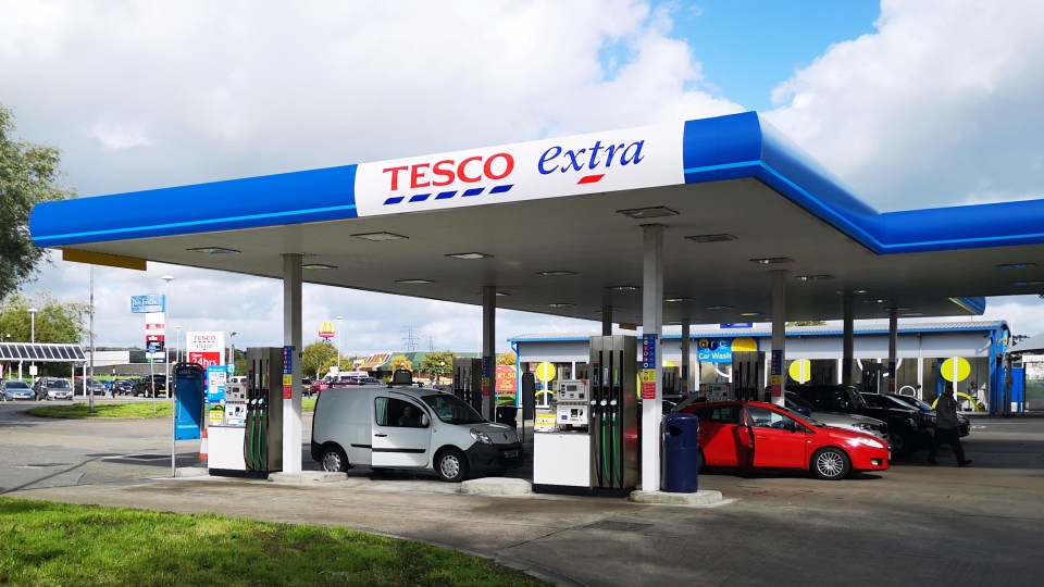 a tesco extra gas station with cars parked outside