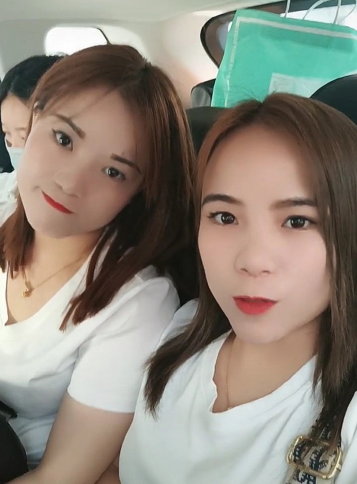 two women in white shirts pose for a picture in a car