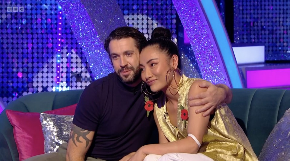 a man and a woman sit on a couch with bbc written on the bottom of the screen