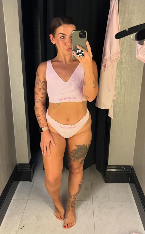 a woman taking a picture of herself in a dressing room