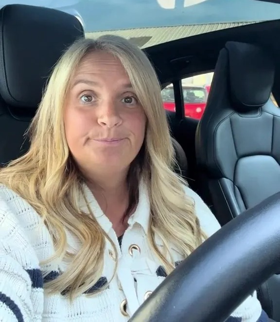 a woman is sitting in the driver 's seat of a car