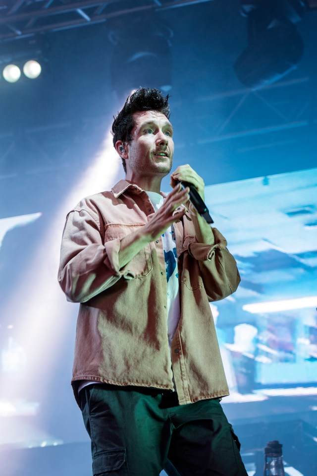 a man singing into a microphone on a stage