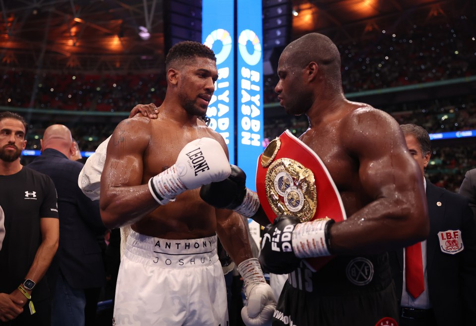 two boxers are standing next to each other and one of them is wearing boxing gloves that say leone