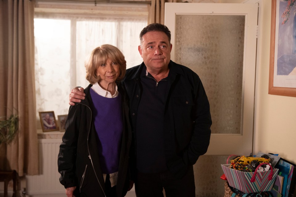 a man and woman standing next to each other in a living room