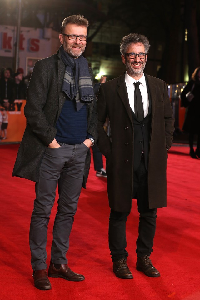 two men are standing on a red carpet in front of a sign that says kit 's